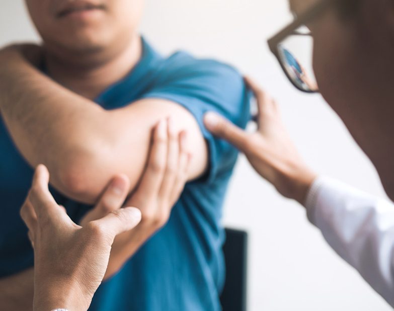 photo of a close-up of a physical therapist looking at a patient's elbow